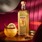 Gran Centenario Reposado bottle on table with Paloma cocktail.