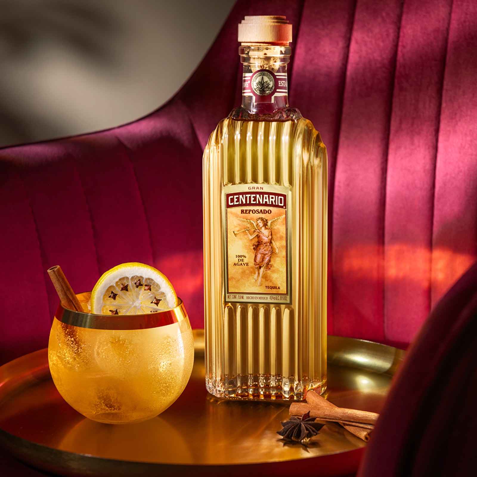 Gran Centenario Reposado bottle on table with Paloma cocktail.